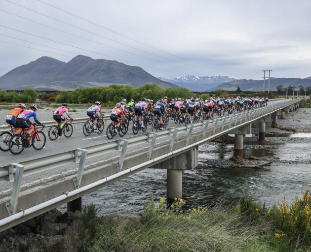 The peloton crosses the Oreti River near Mossburn at the start of the stage.