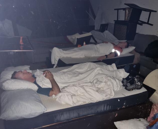 Site Weld employees Chris McBride (front) and Jamie Wilson sleep in their destroyed apartment...
