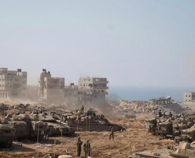 Israeli soldiers and tanks take position inside the Gaza Strip, according to the Israeli Defense...