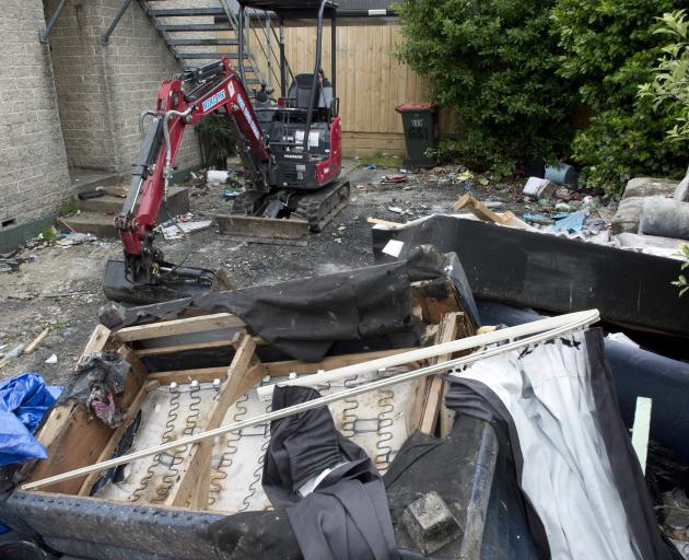 An excavator at the rear of the flat is used to clear large volumes of rubbish. PHOTO: GERARD O...