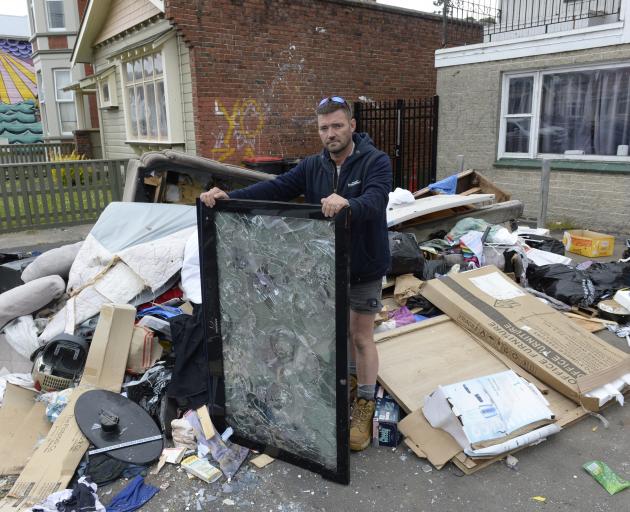 Building manager Anthony Brown stands among a heap of rubbish at the Castle St flat he manages,...
