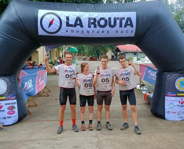 Celebrating their win at the finish line of the La Routa Adventure Race are (from left) Dean...
