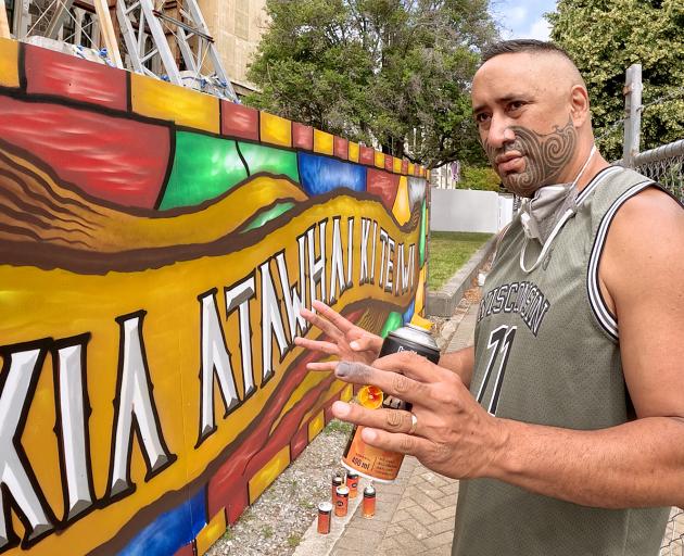 Internationally-renowned artist Mr G working on a mural at the Arts Centre. Photo: Geoff Sloan