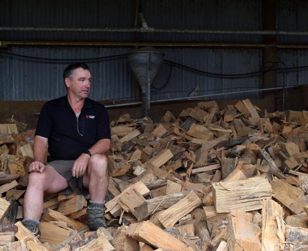 Foxhaven Farms owner Tony Fox sits on firewood seasoning in former piggery pens on his farm in...