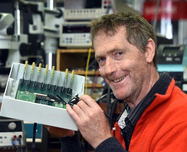 University of Otago physicist Dr Tim Molteno works on a piece of his latest transient array radio...