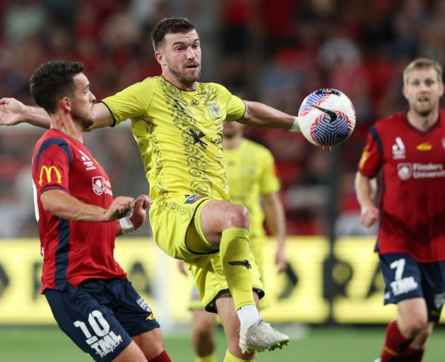 Wellington Phoenix defender Tim Payne challenges for the ball in the clash with Adelaide United...