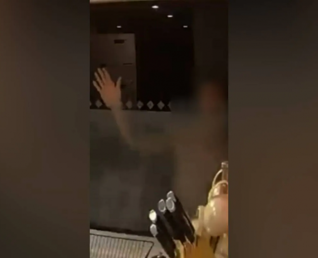 A still from security camera footage of the man waving in the kitchen window.