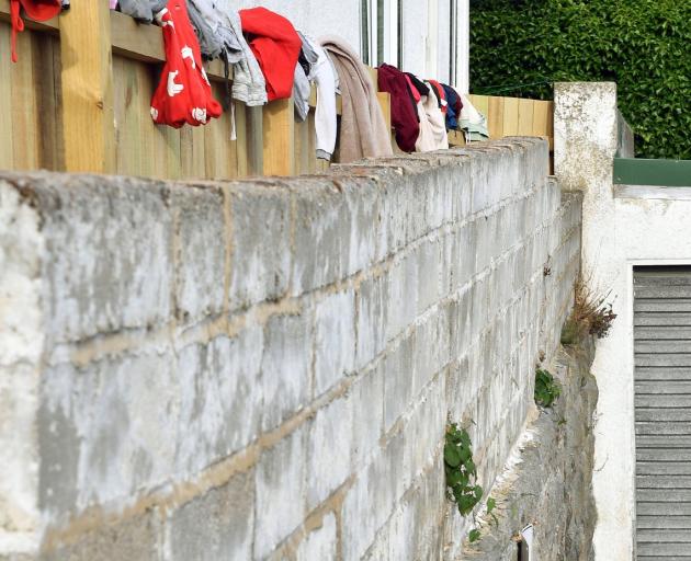 The family’s transitional house is perched high above a busy road, with no fenced garden for the...