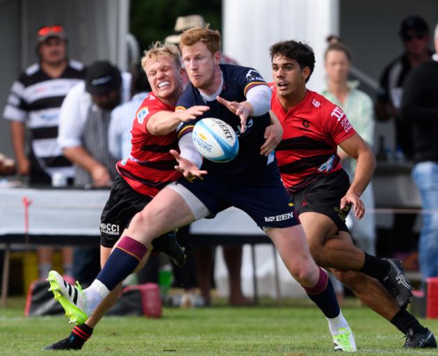 Highlanders first five Rhys Patchell tries to get around Crusaders defenders Blair Murray (left)...