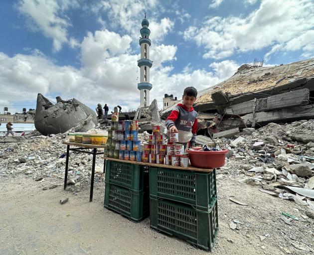 A boy stands next to canned food on offer in Gaza. PHOTO: REUTERS