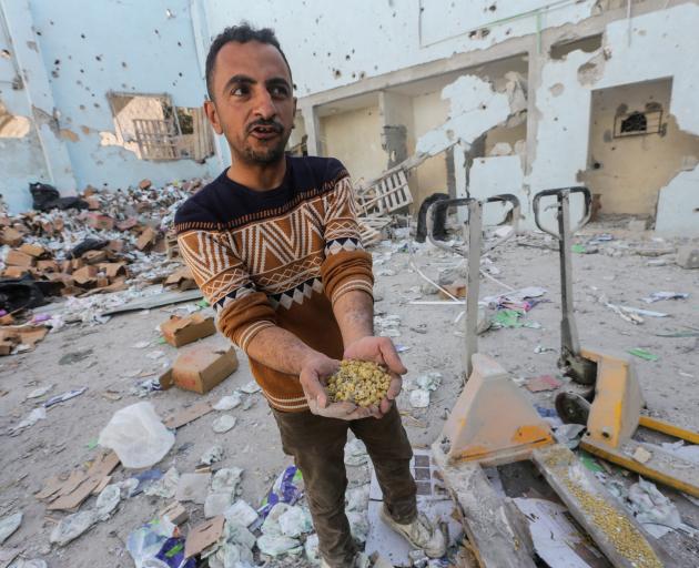 A Palestinian man at the site of an Israeli strike on an aid warehouse in Al-Nuseirat refugee...