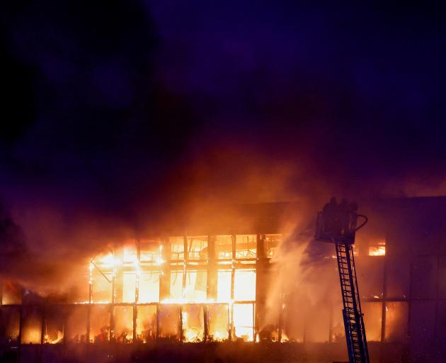Rescuers work to extinguish fire at the burning Crocus City Hall concert venue following a...