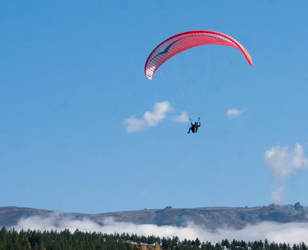 Paraglider Ben Kellet prepares to land on the edge of Lake Dunstan during Acrofest qualifiers in...
