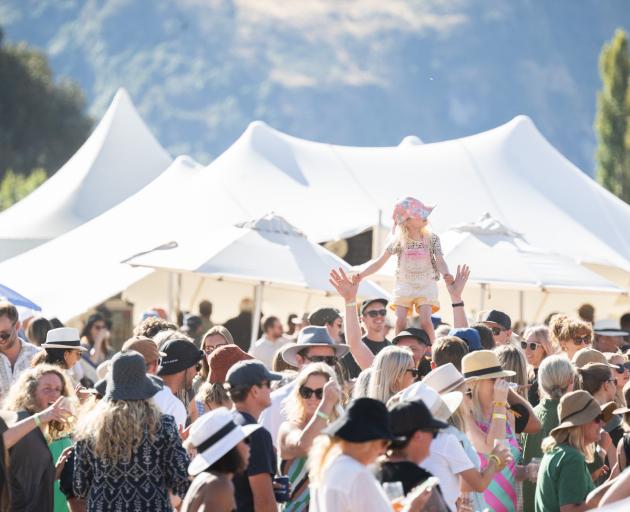 A pint-sized fan stands on top of shoulders to watch Queenstown band Mojo perform.