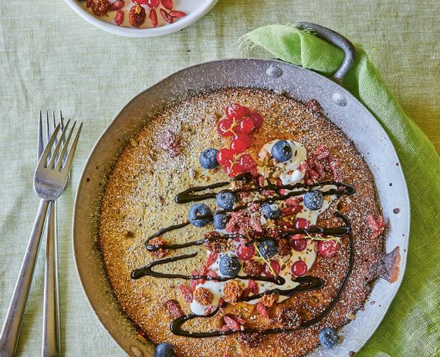 Seeded baked pancake with berries and cocoa sauce.