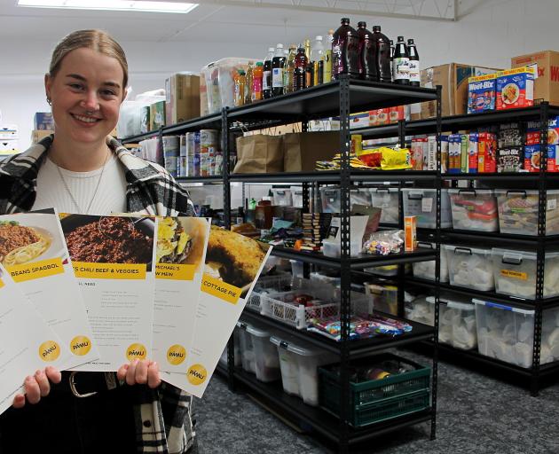 Clutha Budget Advisory Service food hub assistant Jess Michelle holds up recipe cards from their...
