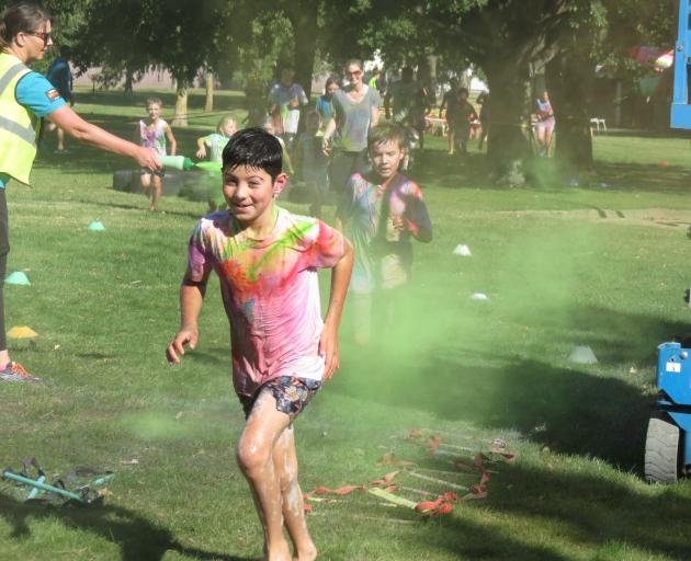 Goldfields pupil Gabe Zareh, 9, dashes through a cloud of dye at the colour run on Sunday. PHOTOS...