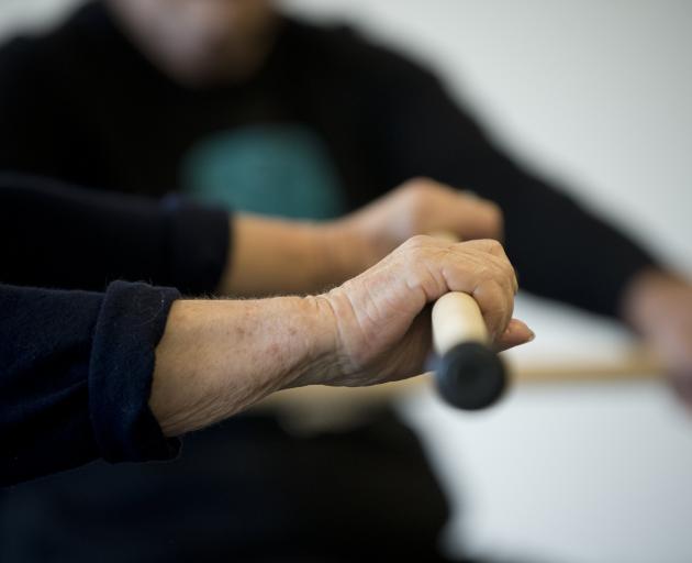Participants work with various tools, including poi and rākau (wooden sticks).