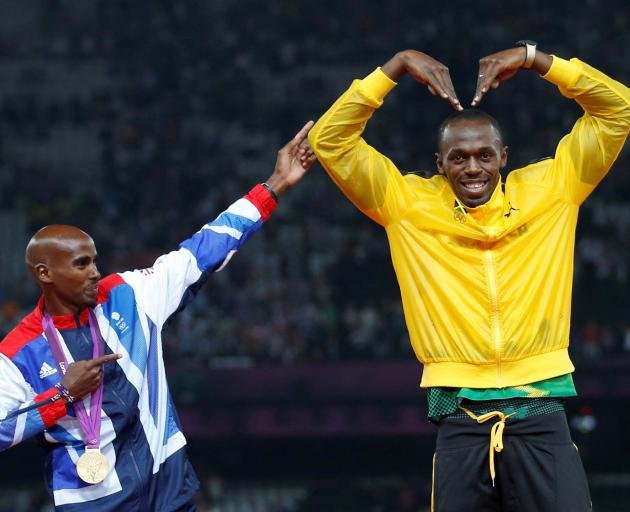 Jamaica's Usain Bolt celebrates with Britain's Mo Farah on the podium after each receiving gold...
