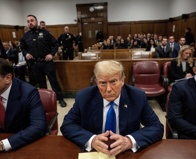 Former US president Donald Trump sits in court on the first day of opening statements in his...