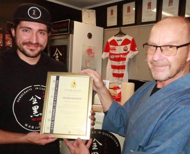 Devon Mederos, left, receiving his Master of Sake certificate from Zenkuro head brewer/director...