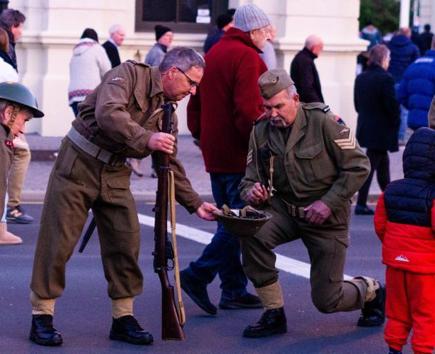 Riflemen pick up their bullet casings after the conclusion of Oamaru’s Anzac Day dawn service....