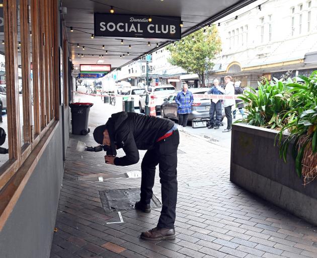 A Dunedin police photographer documents evidence at the scene of a serious assault in Princes St,...