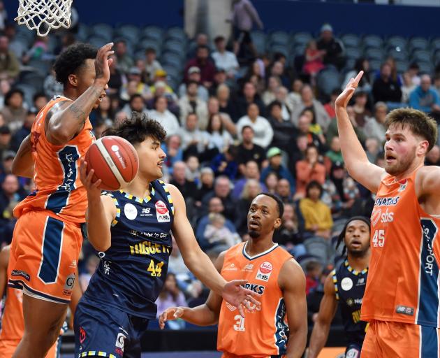Otago Nuggets guard Caleb Smiler passes the ball up court despite the attention of Southland...