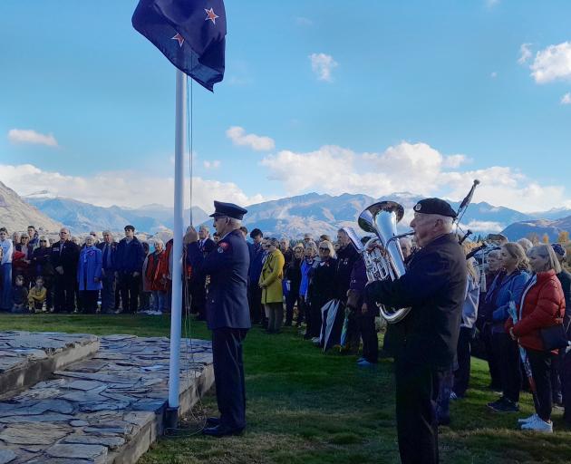 Firefighter Ralph Fegan lowers the flag as David Leslie plays the bugle during the Anzac Day...