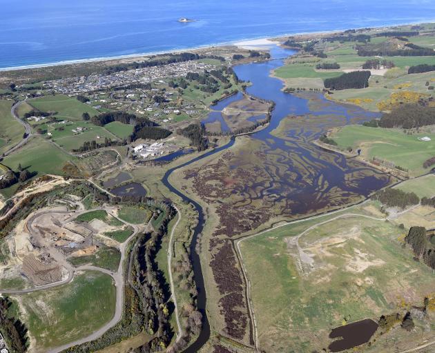 Kaikorai Stream passes the Green Island landfill (at bottom left of the photograph) as it heads...