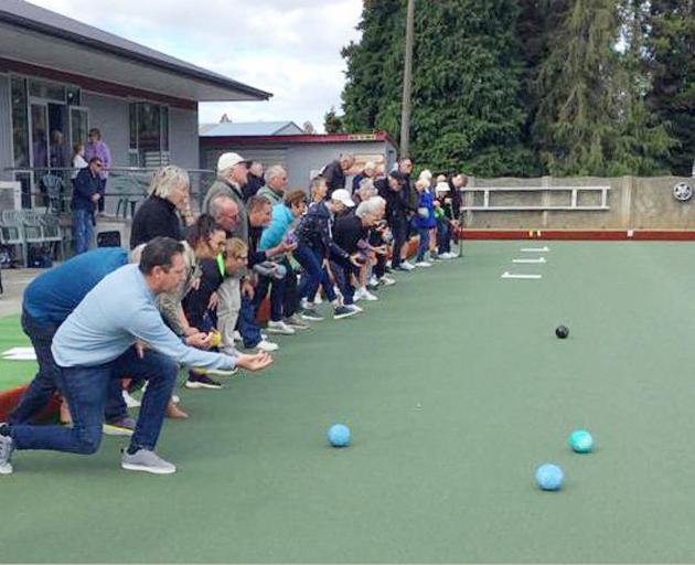 Te Anau Bowling Club members give the club’s new artificial green a test roll. PHOTO: SUPPLIED