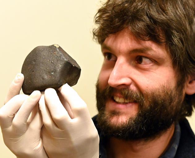 University of Otago geologist Dr Marshall Palmer holds a meteorite that was recently collected...
