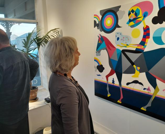 Oasis Clearspace Gallery co-owner and artist Katy Waite admires Michael Cooke’s acrylic on canvas...