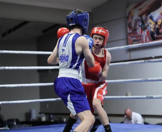Lachlan O’Neill (red) throws a strong straight punch on his way to unanimous decision victory...