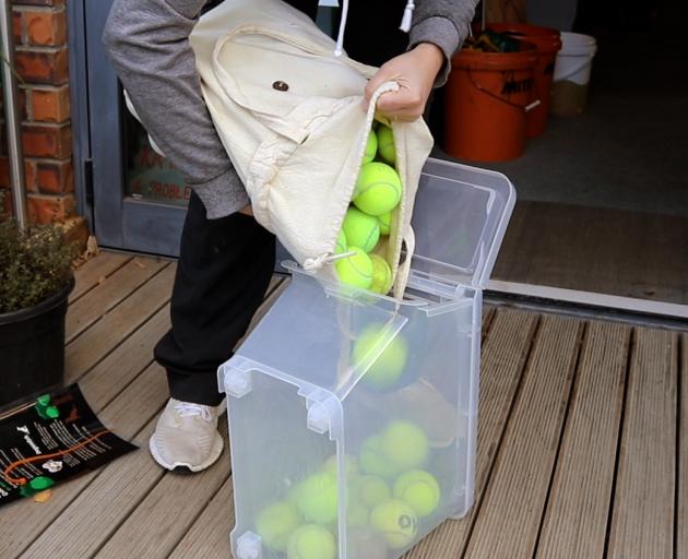 Lena Tiebosch filling the box up with tennis balls from Edgeware Tennis Club. Photo: Emily O'Hagan