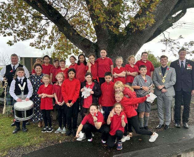 East Gore School pupils and staff stand in front of Rākanui, a tree planted by former headmaster...