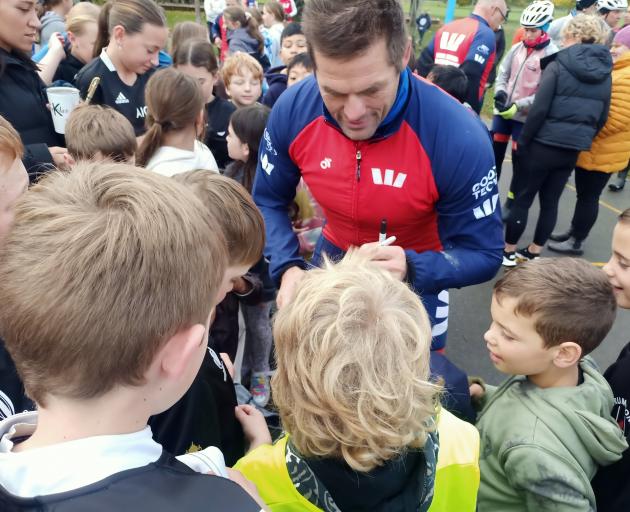Richie McCaw signs autographs for the enthusiastic pupils of Limehills School during a stop on...