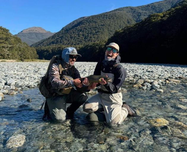Katrina Comeskey catches a fish with guide Jake Berry in the Makarora River during the Casting...