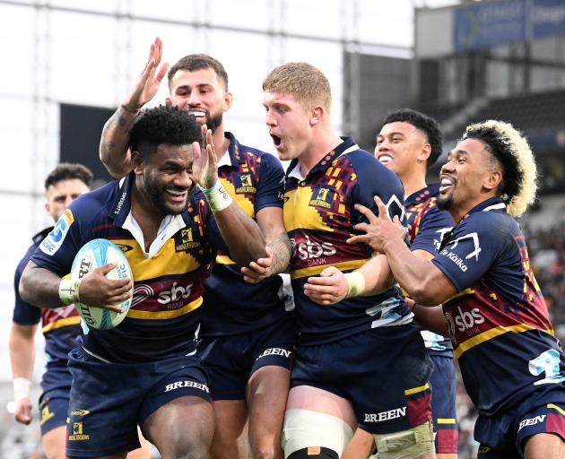 Highlanders winger Timoci Tavatavanawai is congratulated by team-mates (from left) Jacob...