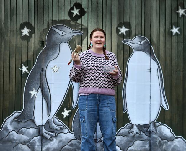 Dunedin artist Bee Lazarevic with her new hoiho artwork, one of many works by street artists to...