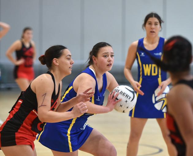 Dunedin wing attack Tia Pavihi (with ball) looks to pass against Christchurch Black in their...