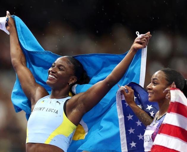 Julien Alfred holds the St Lucian flag after claiming her country's first ever Olympic medal in...