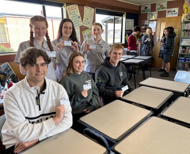 Holding their kindness initiative cards are Dunstan High School students (back, from left)...