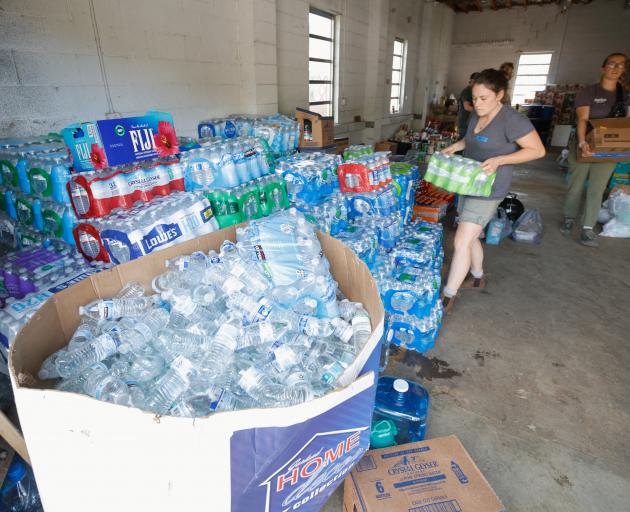 Volunteers sort bottles of water donated to a makeshift community care centre in Barnardsville,...