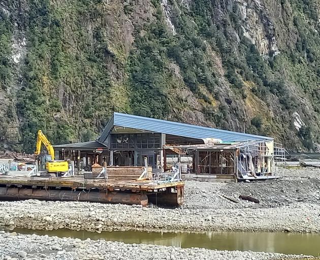 The damaged pontoon buildings were refloated before being moved and secured on shore at Deep...