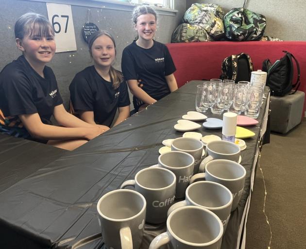 Year 8 students (from left) Lucy Smith, Livy Stratford and Zoey Grant sell coffee mugs, glasses,...