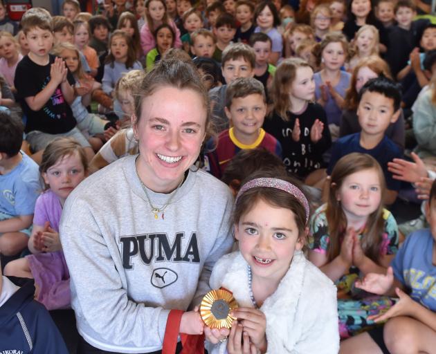 Dunedin Paralympian Anna Grimaldi shows her gold medal to Bronte Jacobs, 6, from her win in the...