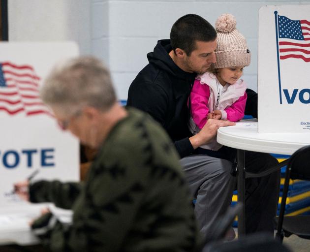 Dustin Ritchie, 34, votes with his daughter in the US presidential election at the Douglas County...