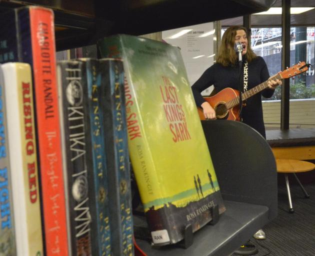 Katie Raven performs a set nestled between romance and contemporary fiction sections in Dunedin...