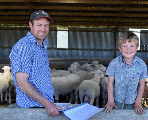 Arkley Farm owner Peter Gardyne and his son Aaron, 4, look at genetic evaluation data of their...